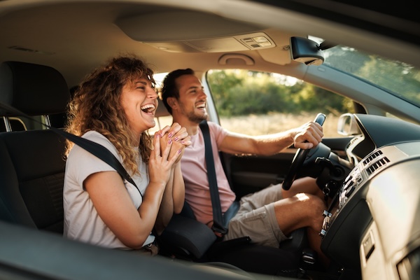 Young couple shares lighthearted moments and laughter during their adventurous car journey